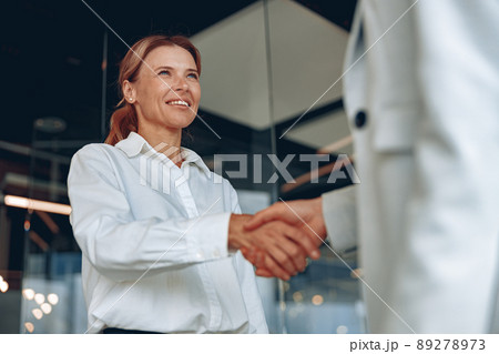 Close up of two confident businesswoman are handshaking before meeting in modern office Close up of two confident businesswoman are handshaking before meeting in modern office 89278973