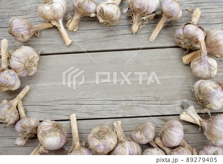 Frame from heads of garlic on vintage wooden background. Flat lay composition. Top view with copy space. Rustic style. Frame from heads of garlic on vintage wooden background. Flat lay composition. Top view with copy space. Rustic style. 89279405