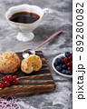 Small white buns with fresh berries with cup of coffee on a concrete texture background 89280082