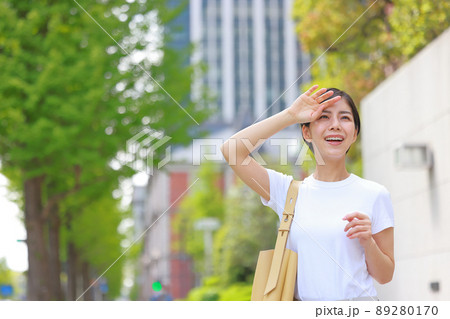 陽射しのまぶしさに手をかざす女性3 89280170