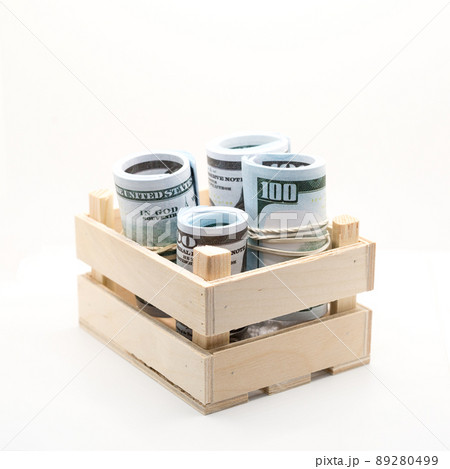 Dollars rolled into a roll and tied with a colored elastic band in a wooden box Dollars rolled into a roll and tied with a colored elastic band in a wooden box 89280499