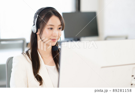 コールセンターで働く若い女性オペレーターの写真素材