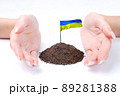 Hand of woman and Ukrainian flag at white background 89281388