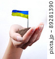 Hand of woman and Ukrainian flag at white background 89281390