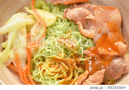 yellow Chinese egg noodles topping Korean fried slice pork with cabbage dressing sukiyaki sauce on bowl 89283064