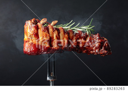 Grilled pork ribs with rosemary on a fork. Grilled pork ribs with rosemary on a fork. 89283263