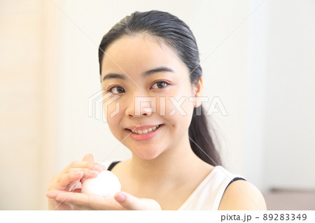 泡を手に取る笑顔の若い女性 泡を手に取る笑顔の若い女性 89283349