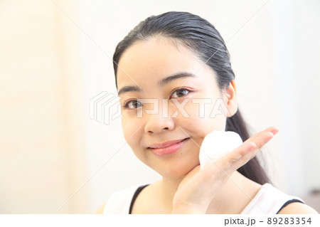 泡を手に取るカメラ目線の若い女性 89283354