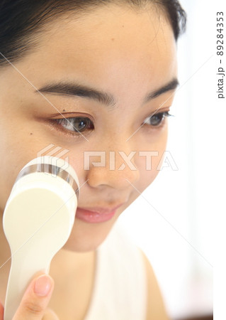 美顔器を当てる気持ちよさそうな女性 89284353