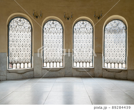 Windows with iron decorated grid, yellow wall, and marble floor Windows with iron decorated grid, yellow wall, and marble floor 89284439