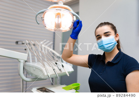 Dentist doctor holding a dental lamp with his hand Dentist doctor holding a dental lamp with his hand 89284490