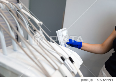 Dentist hand in glove press the control buttons of dental chair 89284494