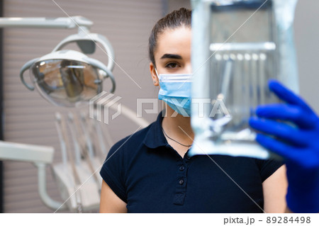 Female dentist doctor holds sterilized instruments Female dentist doctor holds sterilized instruments 89284498
