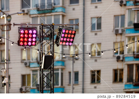 Street lighting with red and pink spotlights on the background of an apartment building in blur. Street lighting with red and pink spotlights on the background of an apartment building in blur. 89284519