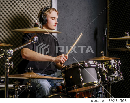 Young man playing drums in a recording studio Young man playing drums in a recording studio 89284563