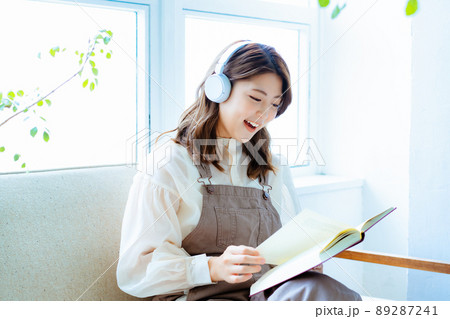 音楽を聴きながら読書をする若い女性 音楽を聴きながら読書をする若い女性 89287241