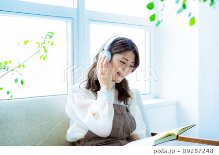 音楽を聴きながら読書をする若い女性 89287248