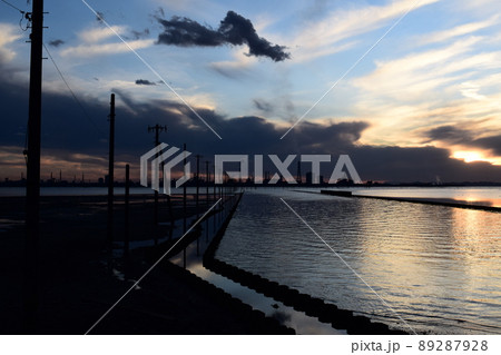 夕暮れ時の海中電柱と対岸に望む工場群 89287928