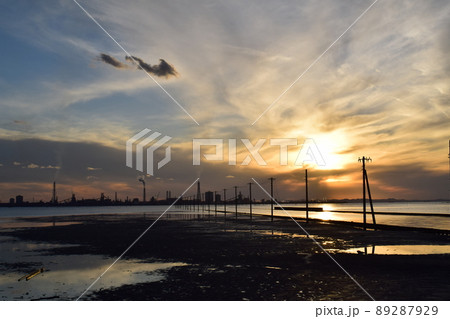 夕暮れ時の海中電柱と対岸に望む工場群 89287929