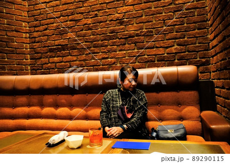 一人でホテルのバーで飲む女性 89290115