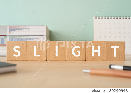 「SLIGHT」と書かれた積み木が置かれたデスク 89290948