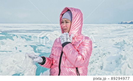 Girl walking on cracked ice of a frozen lake Baikal. Woman trave Girl walking on cracked ice of a frozen lake Baikal. Woman trave 89294977