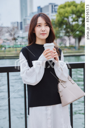 川沿いの遊歩道でコーヒを持つ女性 川沿いの遊歩道でコーヒを持つ女性 89296573