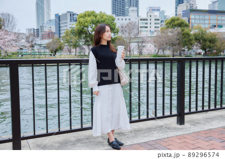 川沿いの遊歩道でコーヒを持つ女性 川沿いの遊歩道でコーヒを持つ女性 89296574