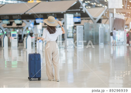 Young woman hand holding luggage handle before checking flight time in airport, Transport, insurance, travel and vacation concepts Young woman hand holding luggage handle before checking flight time in airport, Transport, insurance, travel and vacation concepts 89296939
