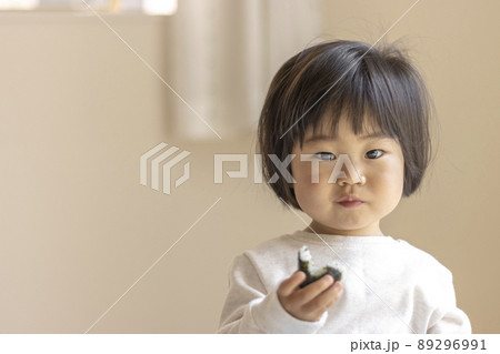 小さいおにぎりを食べる赤ちゃん（1歳9か月、女の子、日本人） 89296991