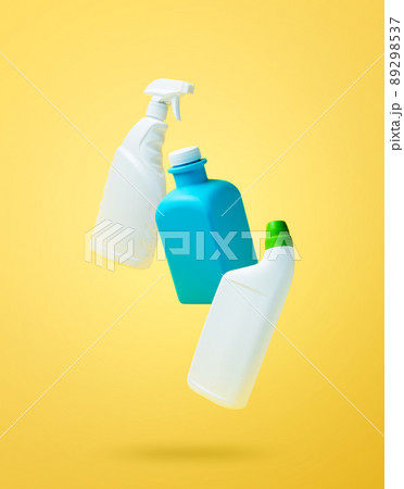 Levitation, falling in air blank household chemical bottles for cleaning the house. Isolated on yellow background. Plastic packaging. Toilet cleaner, detergent sprayer, soap. New brand product mockup 89298537