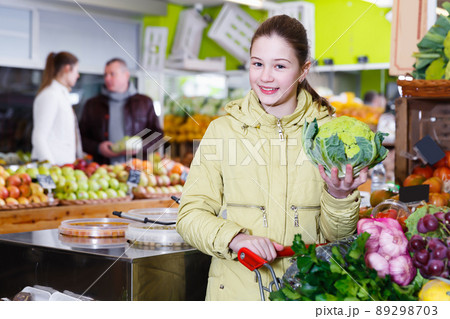 Nice little girl choosing fresh vegetables 89298703