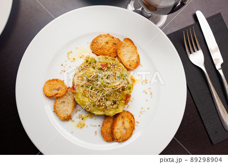 Raw salmon tartare with crispy toasts and guacamole 89298904