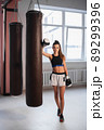 Photo shoot for a young athlete in the interior of a boxing gym with gloves and bags 89299396