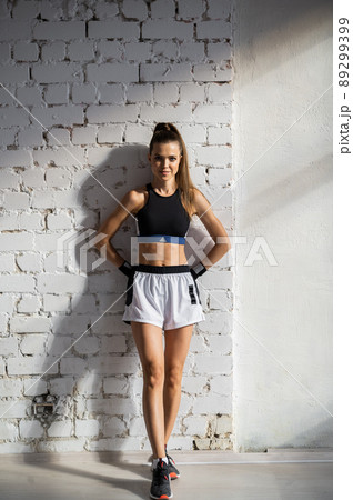 A young female athlete with a perfect body and abs is preparing for training in the early morning A young female athlete with a perfect body and abs is preparing for training in the early morning 89299399