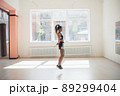 Cute young girl jumping rope in gym, warm up before training 89299404