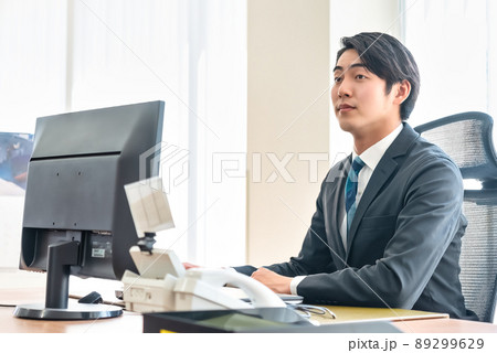 真剣な表情でPCモニターを見つめるビジネスマン 89299629