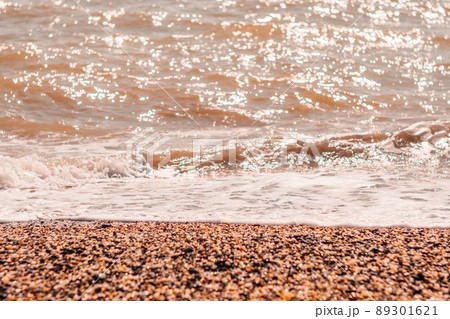 Abstract nature summer or spring ocean sea background. Small waves on golden warm water surface in motion blur with bokeh lights from sunset. Holiday, vacation and recreational background concept 89301621