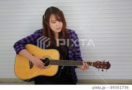 Girl singing on microphone and playing guitar Girl singing on microphone and playing guitar 89301736