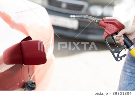 Man filling fuel tank in his hand at gas station. 89301804