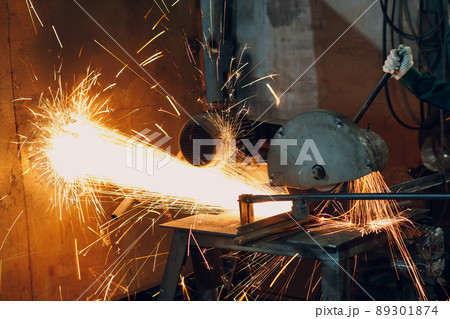Metal processing with big compound mitre saw with circular blade. Sparks in metalworking at factory Metal processing with big compound mitre saw with circular blade. Sparks in metalworking at factory 89301874