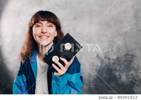 Young sporty woman 80 and 90's style. 90s fashion positive girl with cassette dvd. Young sporty woman 80 and 90's style. 90s fashion positive girl with cassette dvd. 89301912