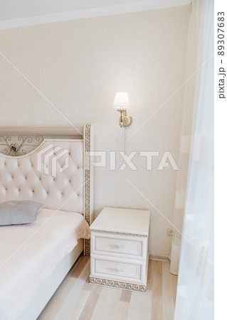 a large classic bed with a soft headboard and covering bedside table . a large classic bed with a soft headboard and covering bedside table . 89307683
