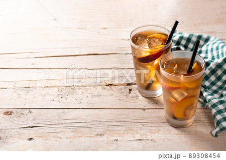 Glass of peach tea with ice cubes 89308454