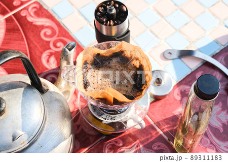 Drip brewing coffee by paper filtered on table morning outdoor Drip brewing coffee by paper filtered on table morning outdoor 89311183