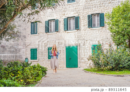 Woman tourist enjoying Colorful street in Old town of Kotor on a sunny day, Montenegro. Travel to Montenegro concept Woman tourist enjoying Colorful street in Old town of Kotor on a sunny day, Montenegro. Travel to Montenegro concept 89311645