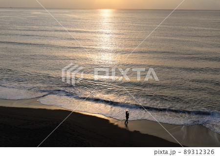 朝焼けの海岸で釣りをする人 89312326