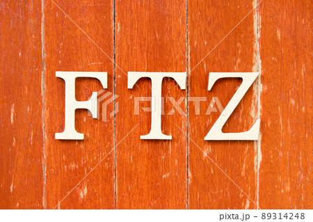 Alphabet letter in word FTZ (Abbreviation of Free trade zone) on old red color wood plate background 89314248