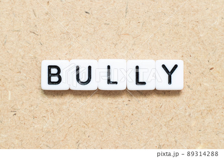 White tile alphabet letter with word bully on wood background White tile alphabet letter with word bully on wood background 89314288