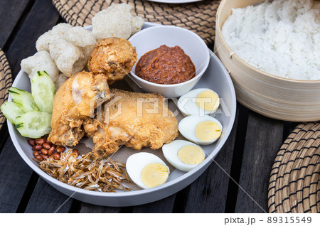 Nasi lemak with fried chicken, anchovis, eggs, groundnuts and sambal is popular Malaysia delicacy, served with rice cooked in coconut milk 89315549